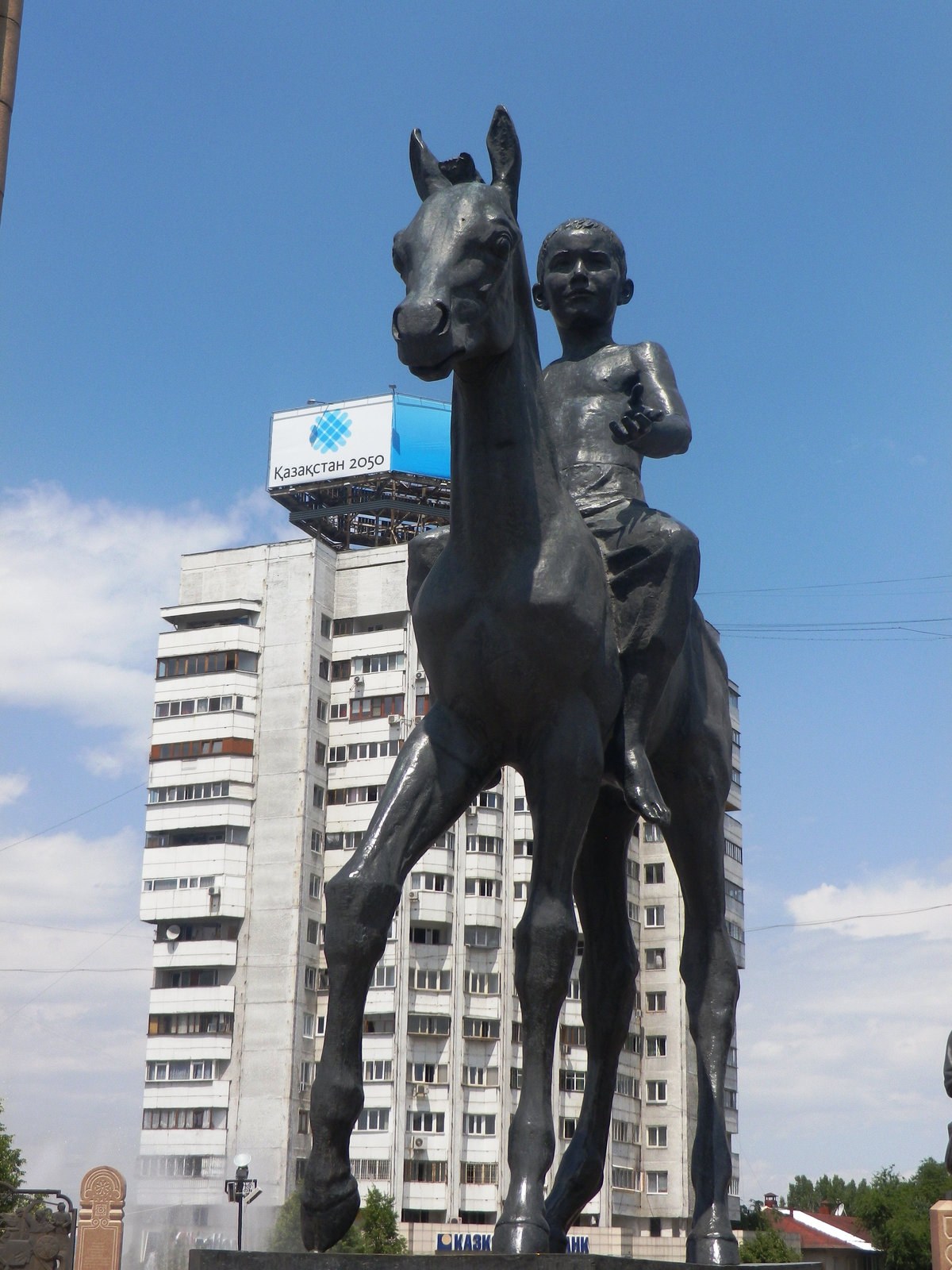 A bronze horse and rider statue in Almaty